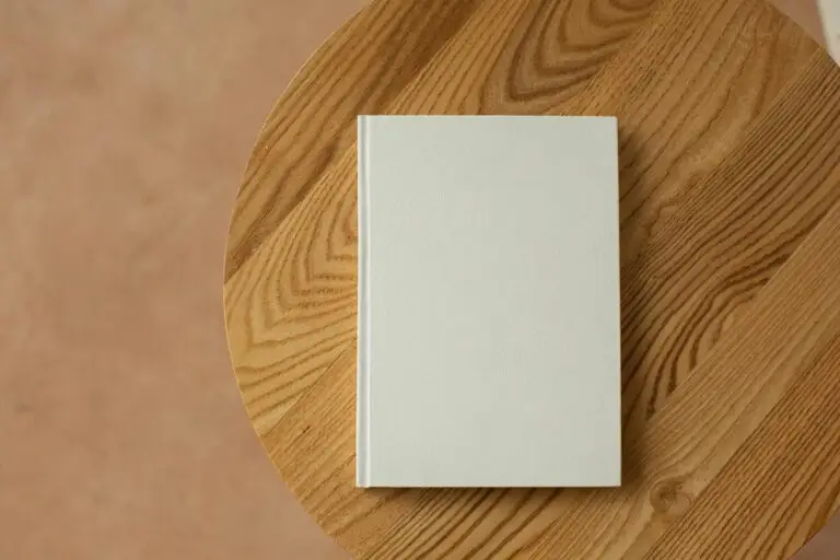 Minimalist white book on a wooden table, representing clean design and SEO sales copywriting that improves conversions behind SEO-rich sales pages.