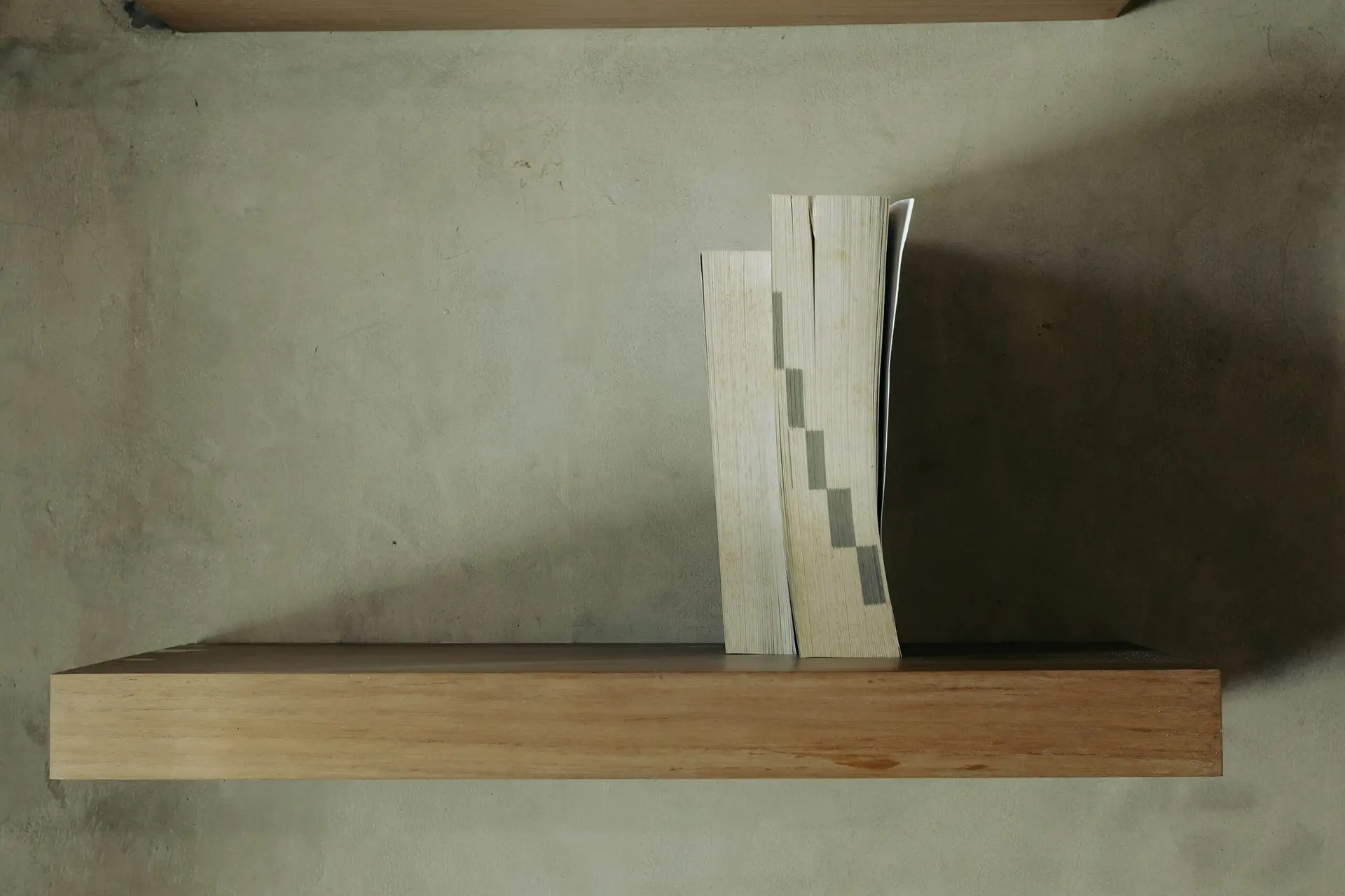 Stack of books on a minimalist shelf, representing SEO blog writing strategy for ecommerce brands.